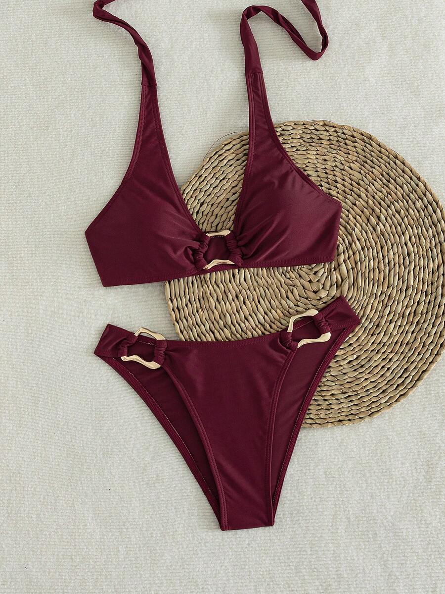 Women's 2-piece solid color halter bikini set featuring a backless tie-back wireless top and mid-waist swimsuit bottoms.