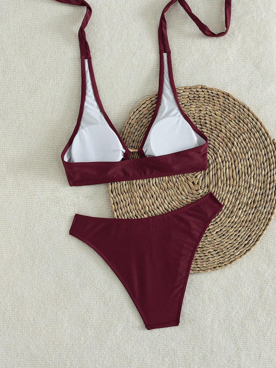 Women's 2-piece solid color halter bikini set featuring a backless tie-back wireless top and mid-waist swimsuit bottoms.