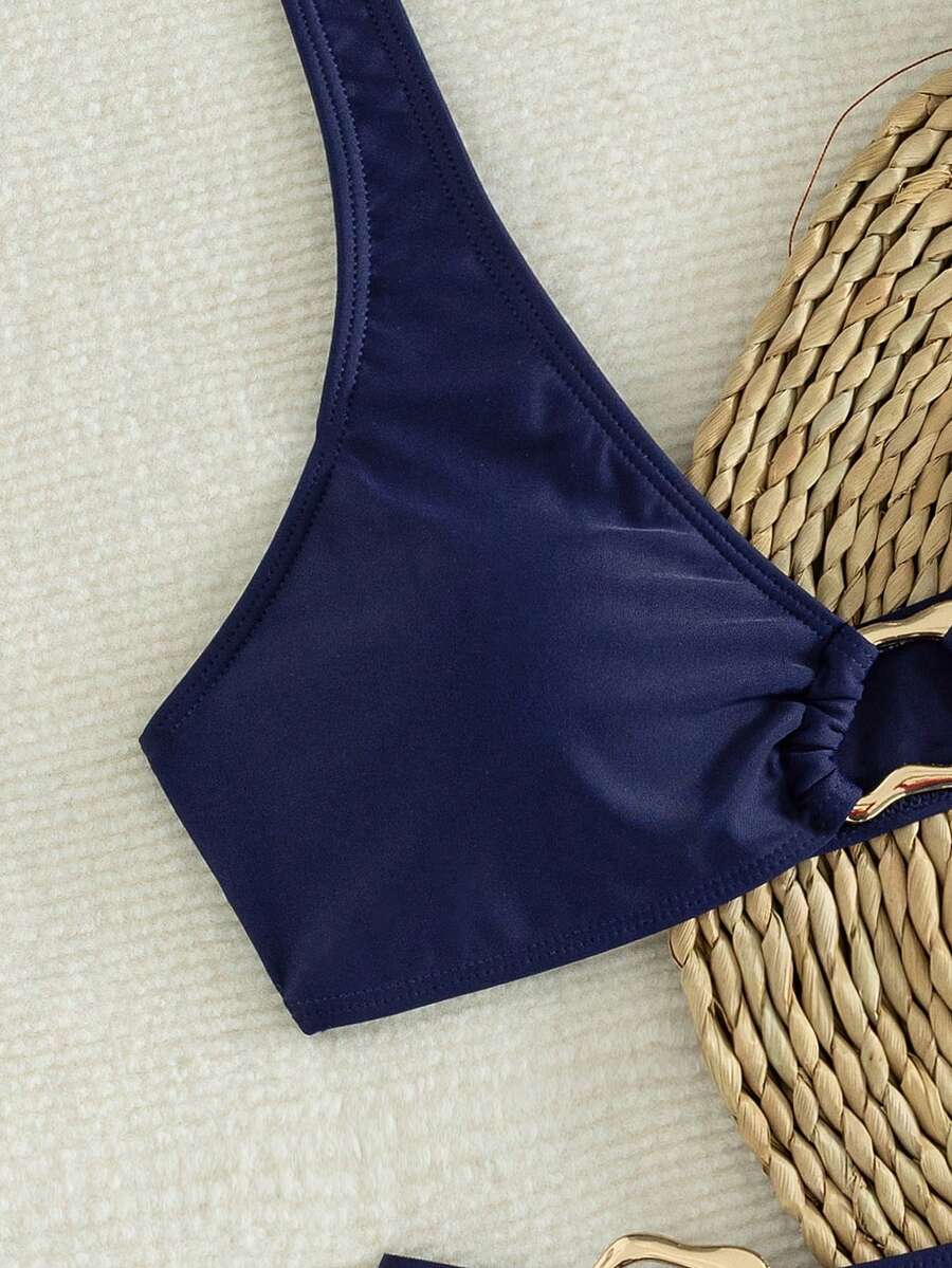 Women's 2-piece solid color halter bikini set featuring a backless tie-back wireless top and mid-waist swimsuit bottoms.
