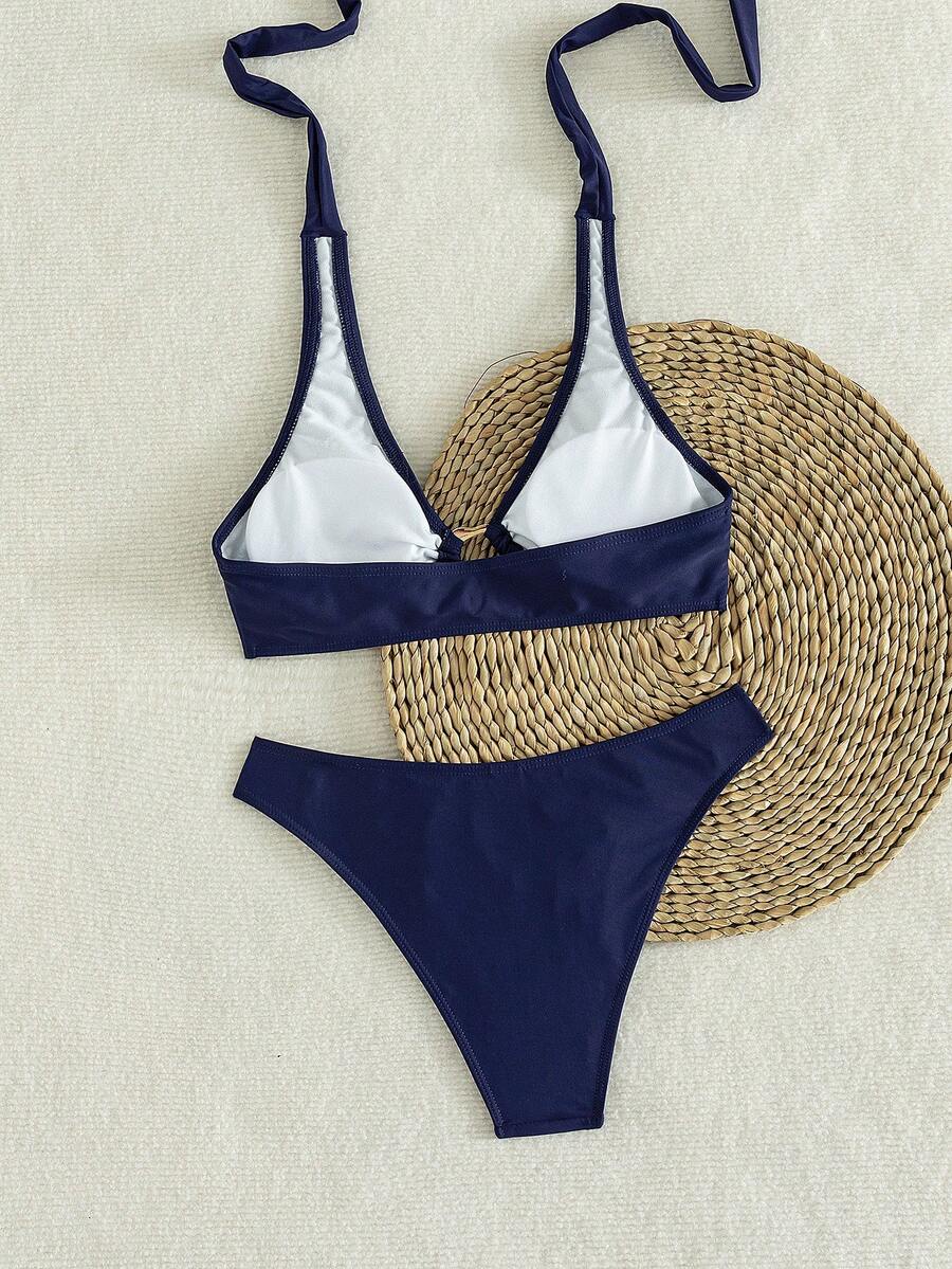 Women's 2-piece solid color halter bikini set featuring a backless tie-back wireless top and mid-waist swimsuit bottoms.