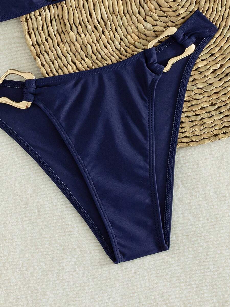 Women's 2-piece solid color halter bikini set featuring a backless tie-back wireless top and mid-waist swimsuit bottoms.