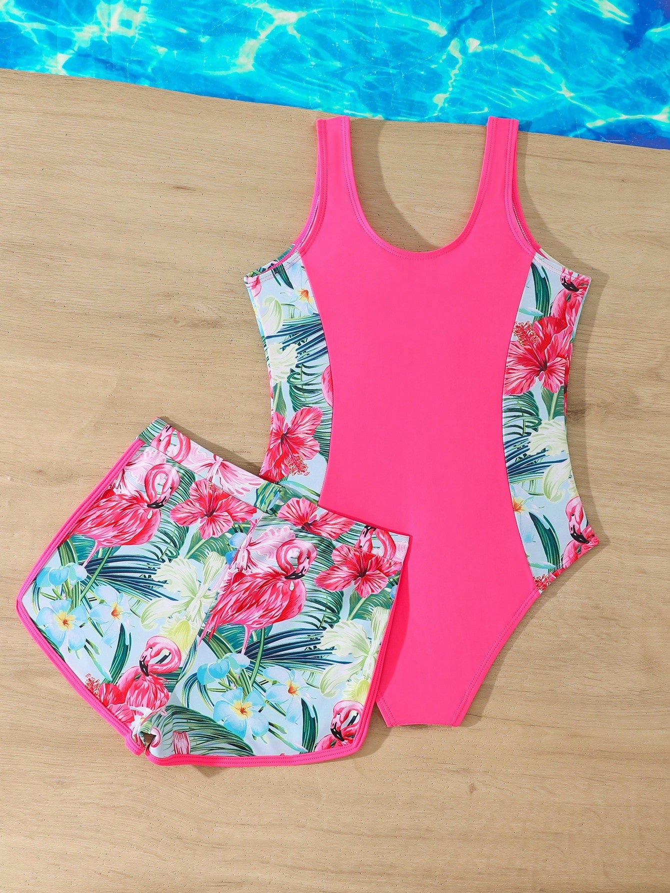 Tween girls 2-piece swimsuit set in black with full floral and plant print, featuring a sleeveless scoop-neck swim top and matching shorts-style bottoms.