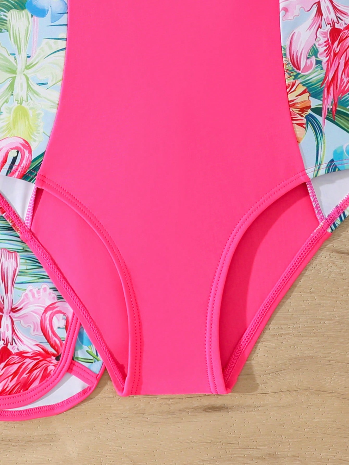 Tween girls 2-piece swimsuit set in black with full floral and plant print, featuring a sleeveless scoop-neck swim top and matching shorts-style bottoms.