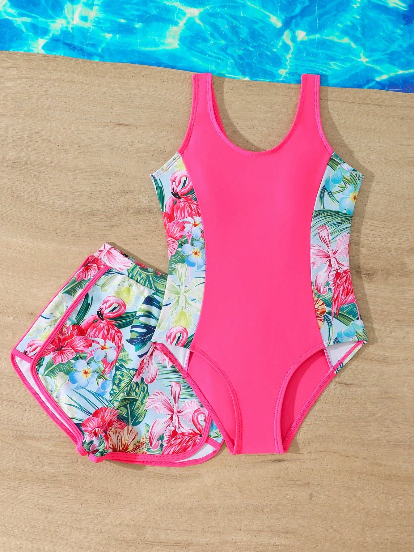 Tween girls 2-piece swimsuit set in black with full floral and plant print, featuring a sleeveless scoop-neck swim top and matching shorts-style bottoms.