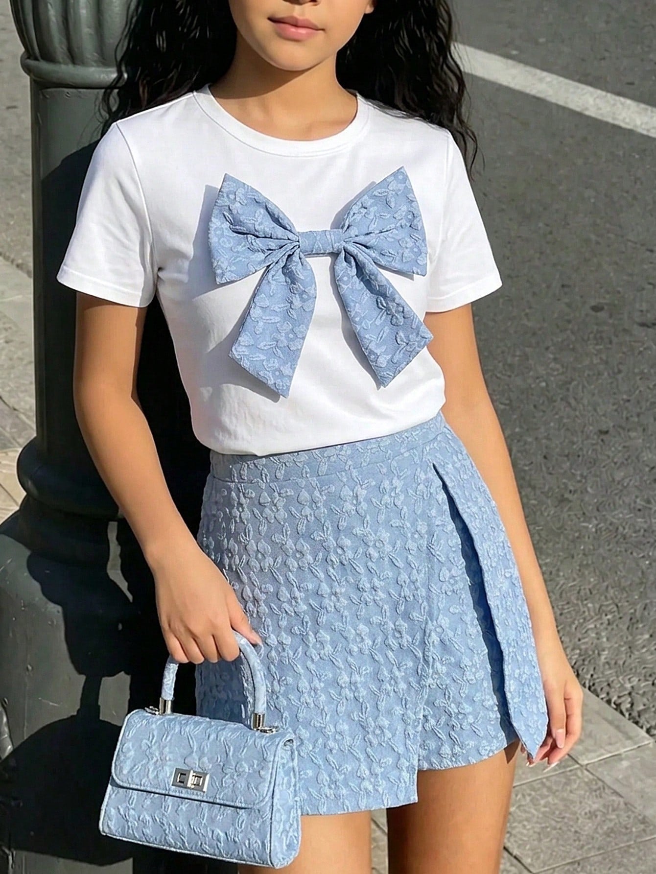 Tween girls 2-piece blue outfit featuring a short sleeve round neck t-shirt with a bow front detail and an asymmetric wrap skort.