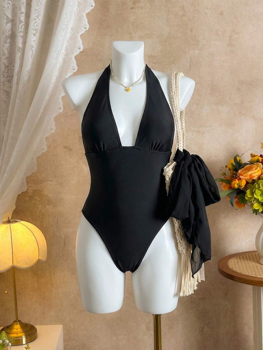 Women's apricot polka dot two-piece swimsuit featuring an asymmetrical halter backless top with knot tie detail and high-waisted bottoms.