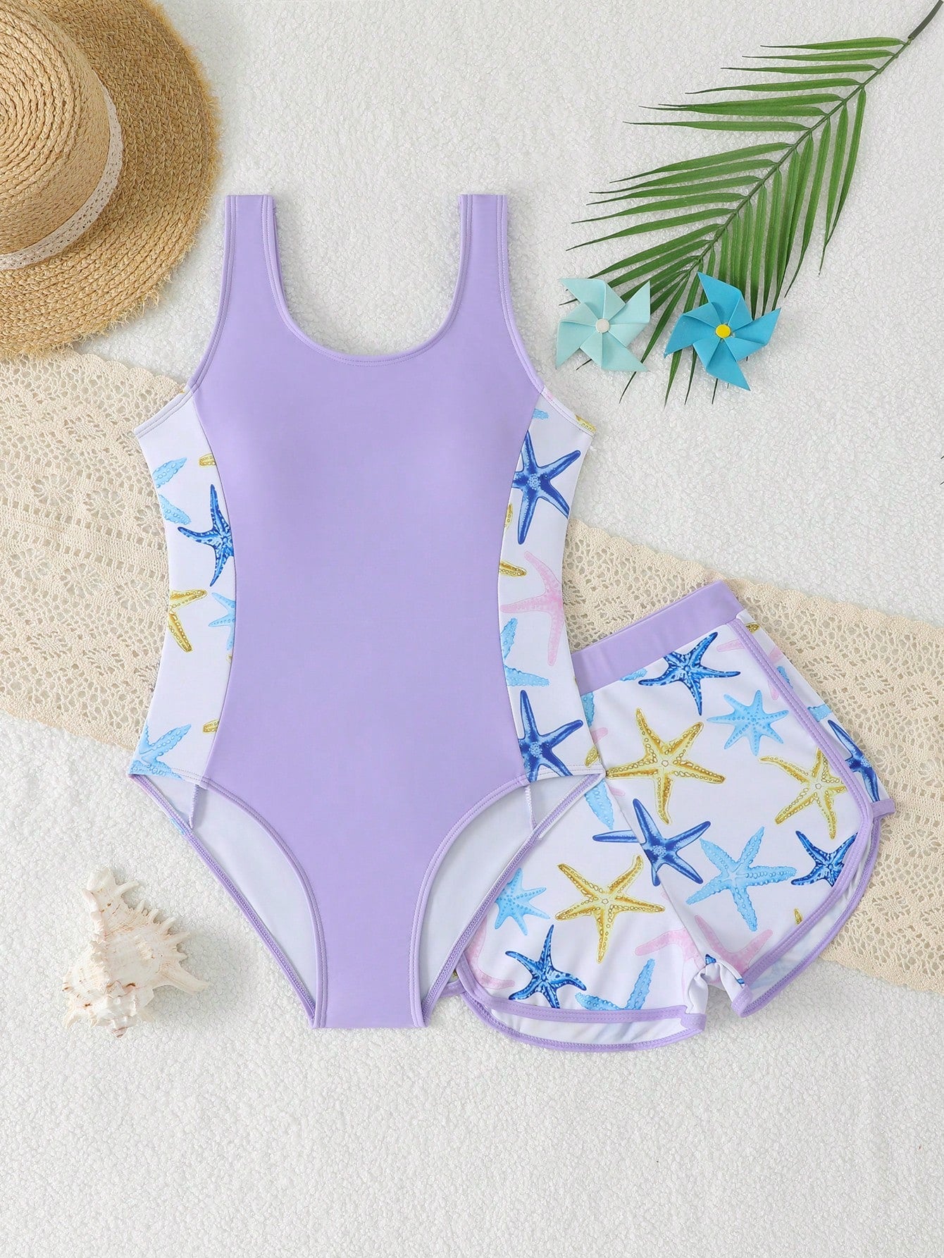 Tween girls 2-piece swimsuit set in black with full floral and plant print, featuring a sleeveless scoop-neck swim top and matching shorts-style bottoms.