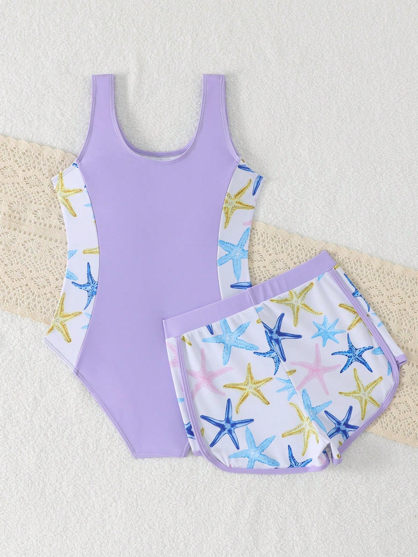 Tween girls 2-piece swimsuit set in black with full floral and plant print, featuring a sleeveless scoop-neck swim top and matching shorts-style bottoms.