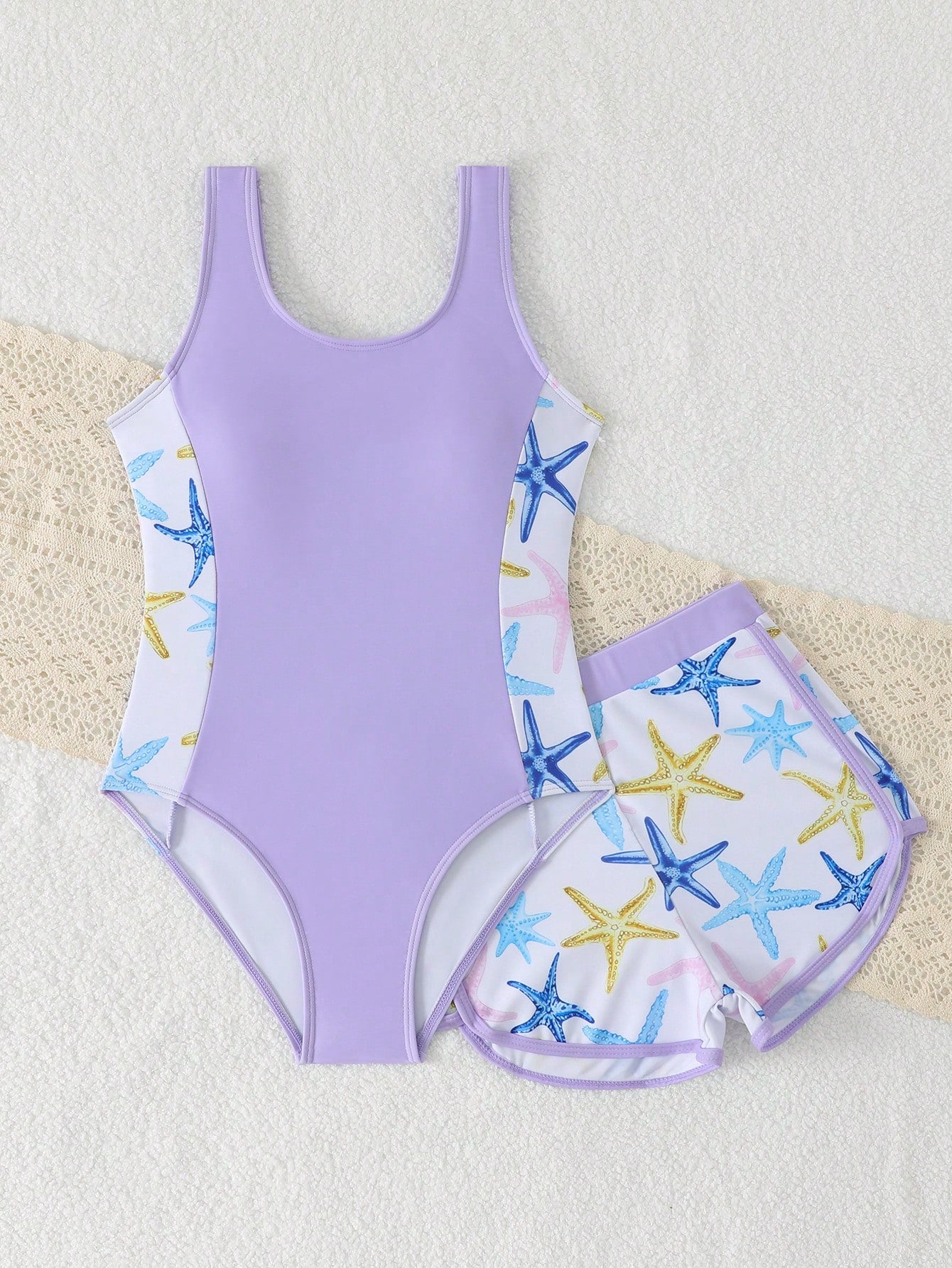 Tween girls 2-piece swimsuit set in black with full floral and plant print, featuring a sleeveless scoop-neck swim top and matching shorts-style bottoms.