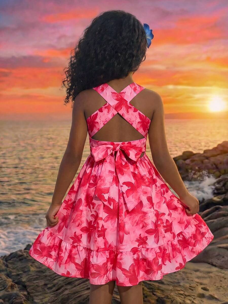 Pink sleeveless tween girls vacation dress with all-over fruit and vegetable print, strap neckline, belted high waist, cut-out detail, and flared ruffle hem.