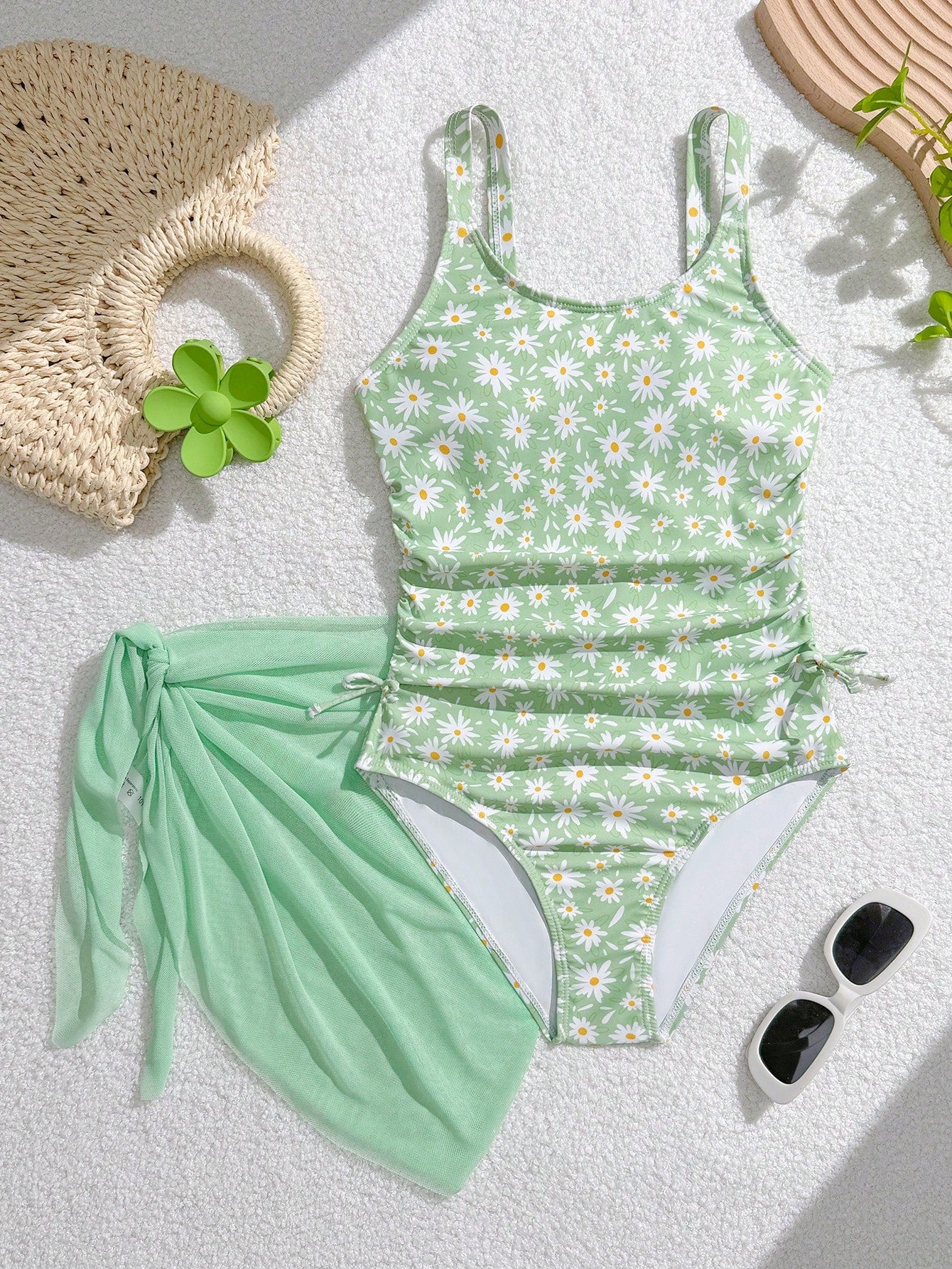 Tween girls 2-piece swimsuit in black with pink floral print, featuring spaghetti straps, bow decor, mesh detail, and a skirted mid-waist bottom. Sleeveless vacation-style swim set with medium-stretch fabric.