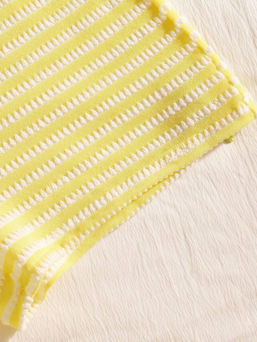 Tween girls black and white striped two-piece set featuring a spaghetti strap micro crop tank top with lettuce trim and ruffle hem paired with matching slim fit shorts.