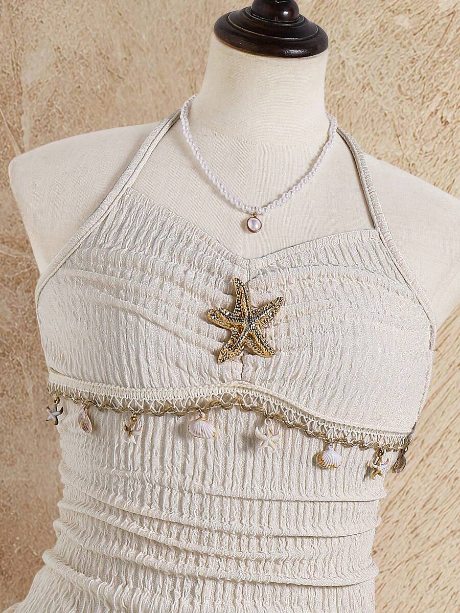 Tween girls apricot sleeveless halter mini dress with textured starfish and shell decor, shirred tiered layer, high waist, and flounce hem.