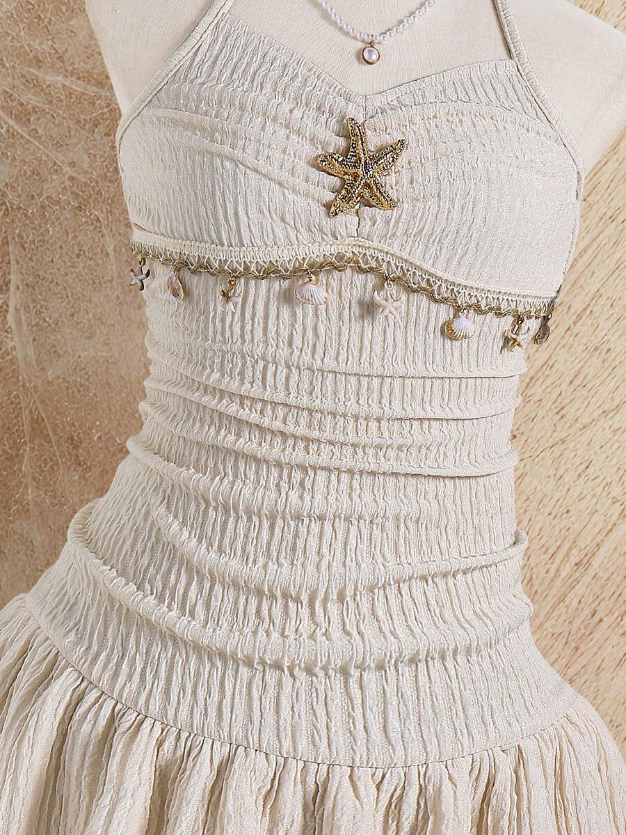 Tween girls apricot sleeveless halter mini dress with textured starfish and shell decor, shirred tiered layer, high waist, and flounce hem.