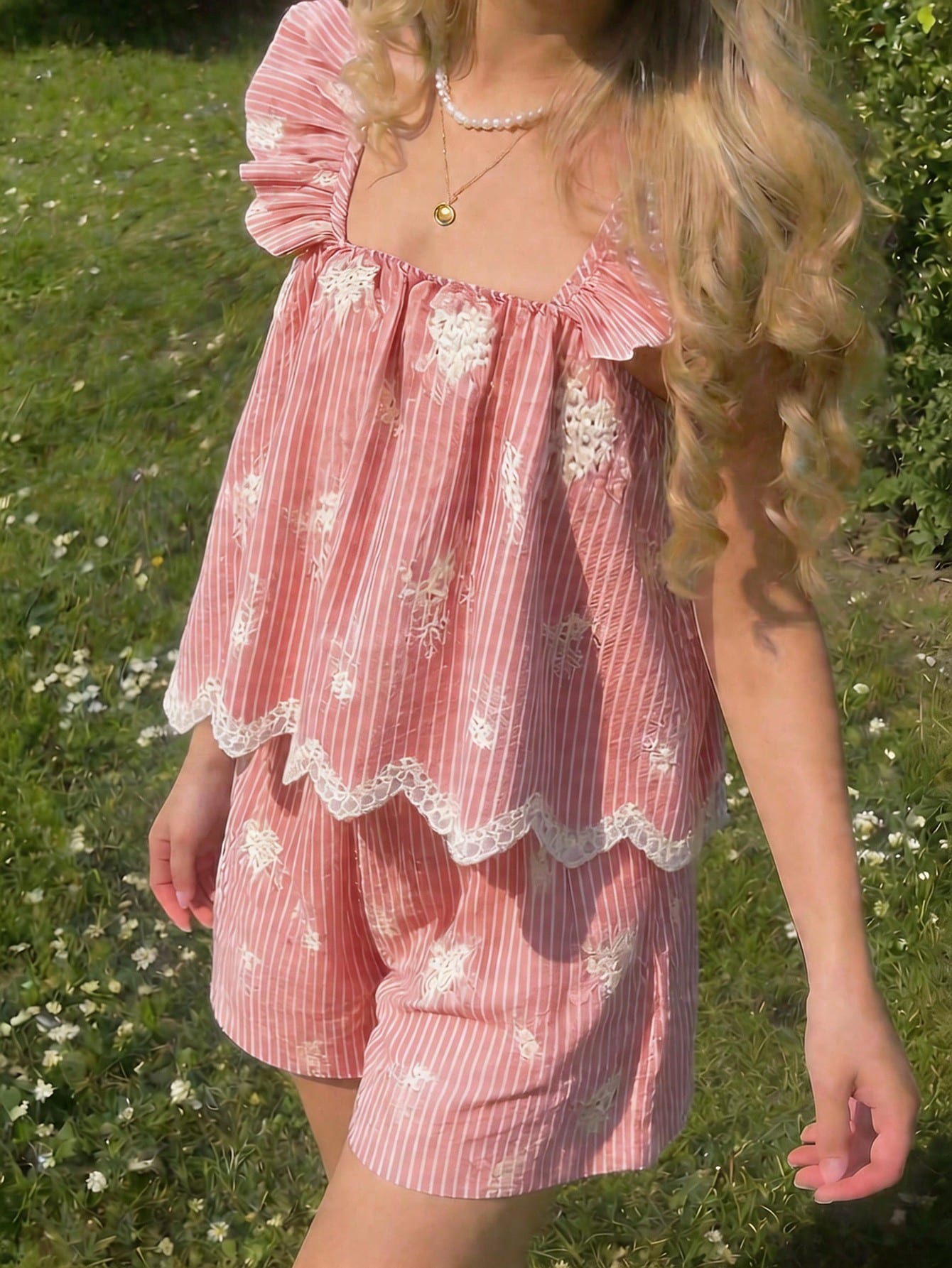 Tween girl wearing a blue and white striped sleeveless top featuring embroidery details and ruffle trim with matching shorts.