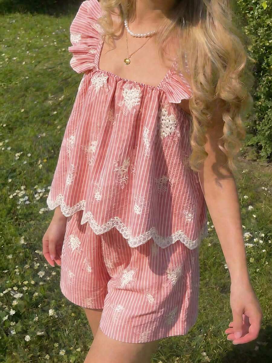 Tween girl wearing a blue and white striped sleeveless top featuring embroidery details and ruffle trim with matching shorts.