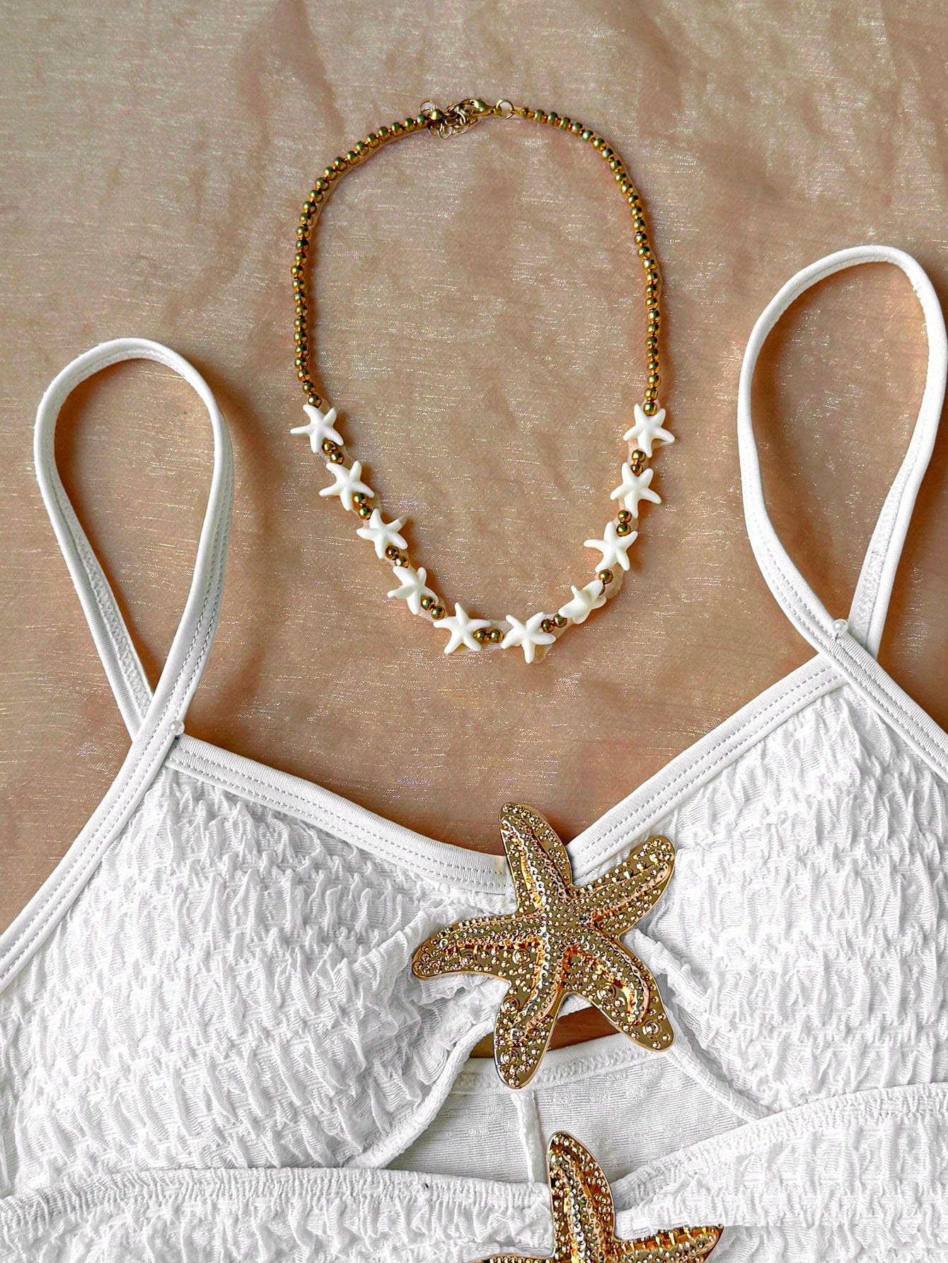 Apricot one-piece swimsuit for tween girls with a halter neckline, ruffle trim, textured knit fabric, fitted shape, and starfish metal decor.