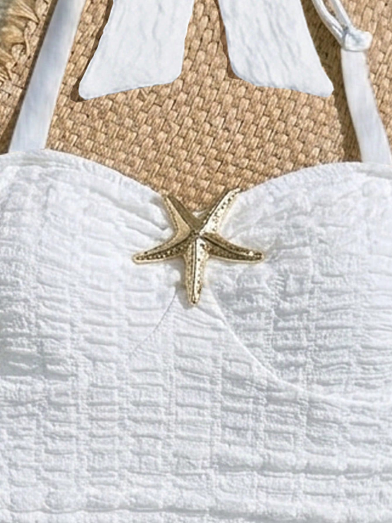 White tween girls one-piece swimsuit with textured fabric, spaghetti straps, tie bow detail, halter style, and open back for summer beachwear.
