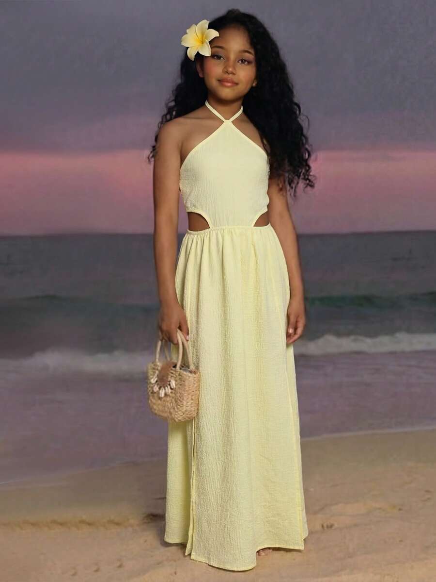 Tween girl yellow long halter dress with cutout waist, split detail, shirred textured fabric, sleeveless design, high waist, and flared hem for beach vacation wear.