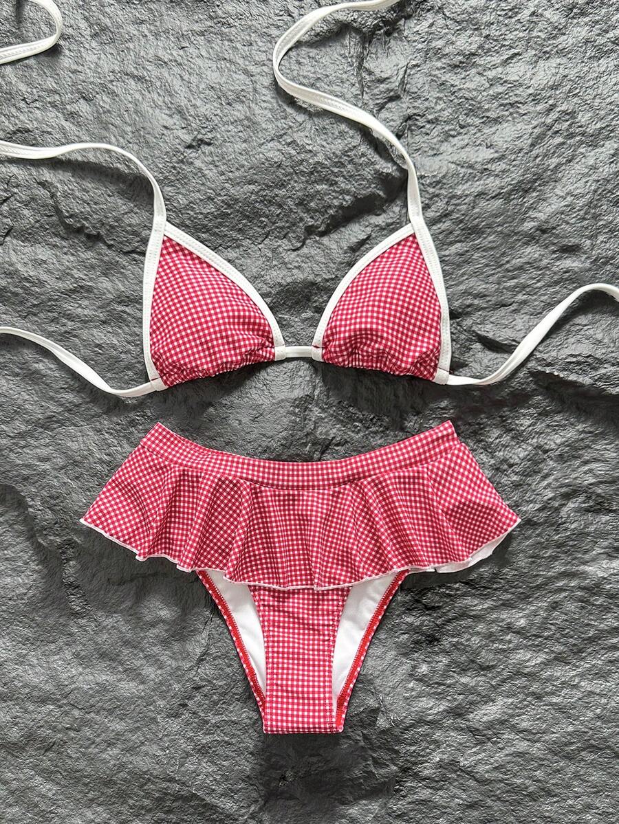 Women's 70s retro black and white polka dot bikini set featuring a halter triangle top and ultra low waist bottoms.