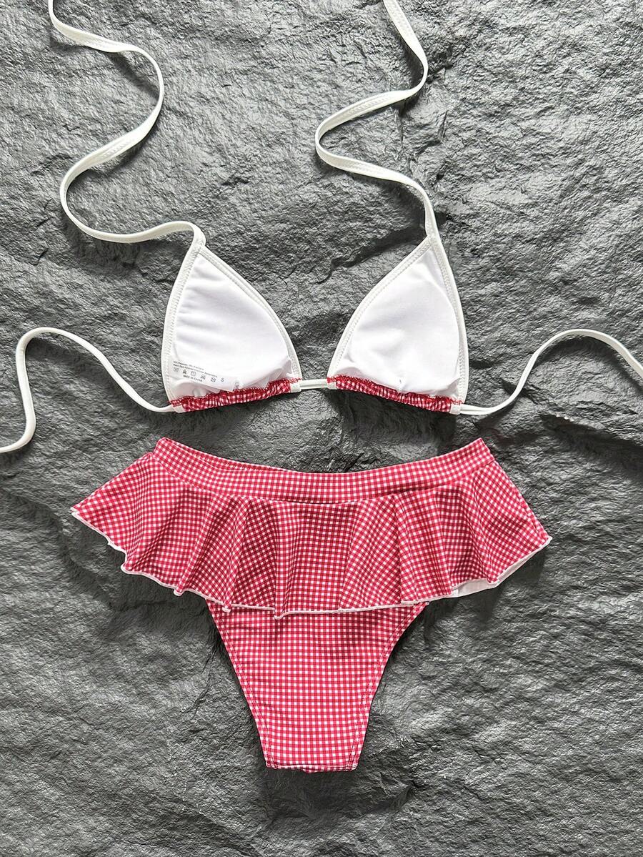 Women's 70s retro black and white polka dot bikini set featuring a halter triangle top and ultra low waist bottoms.