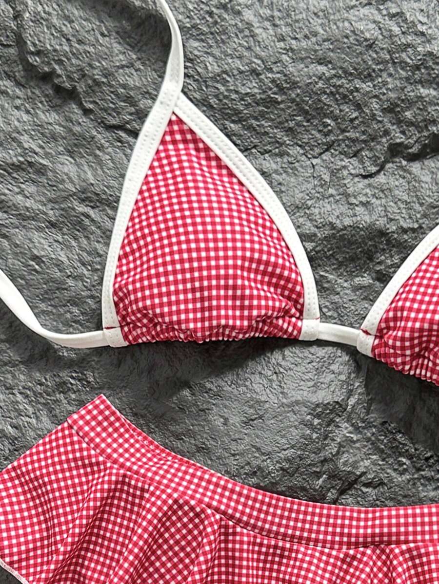 Women's 70s retro black and white polka dot bikini set featuring a halter triangle top and ultra low waist bottoms.