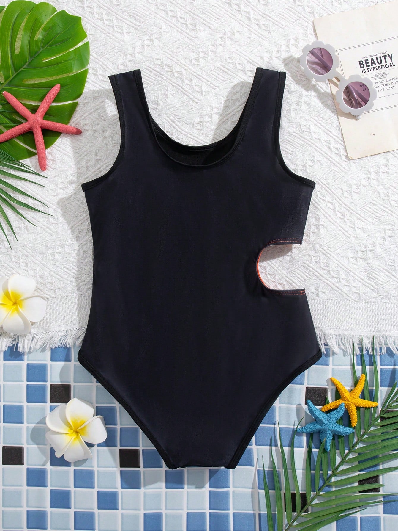 Tween girls' black and white one-piece swimsuit with striped patchwork design, scoop neck, asymmetrical cut-out detail, and fitted vacation swimwear style.
