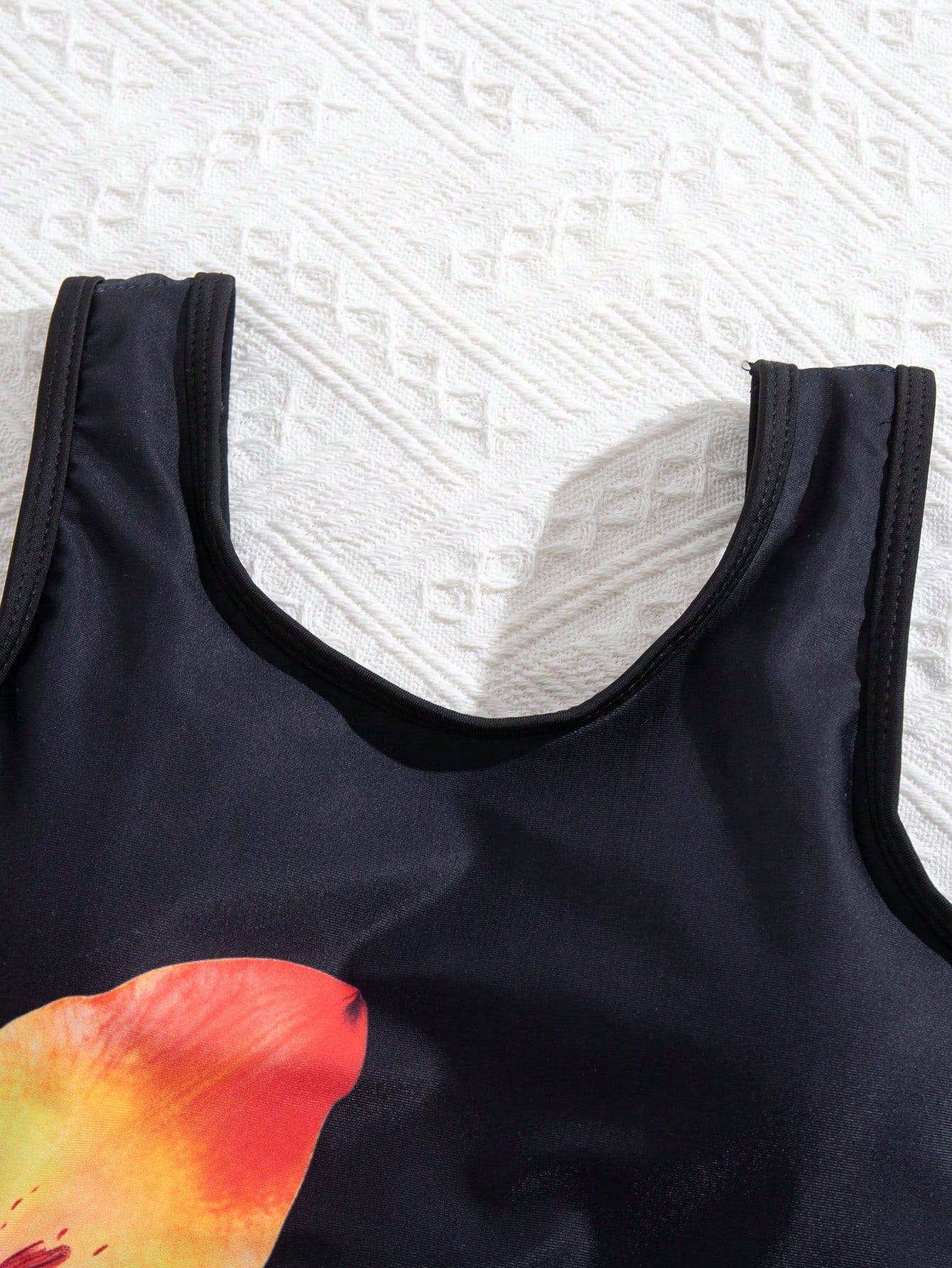 Tween girls' black and white one-piece swimsuit with striped patchwork design, scoop neck, asymmetrical cut-out detail, and fitted vacation swimwear style.