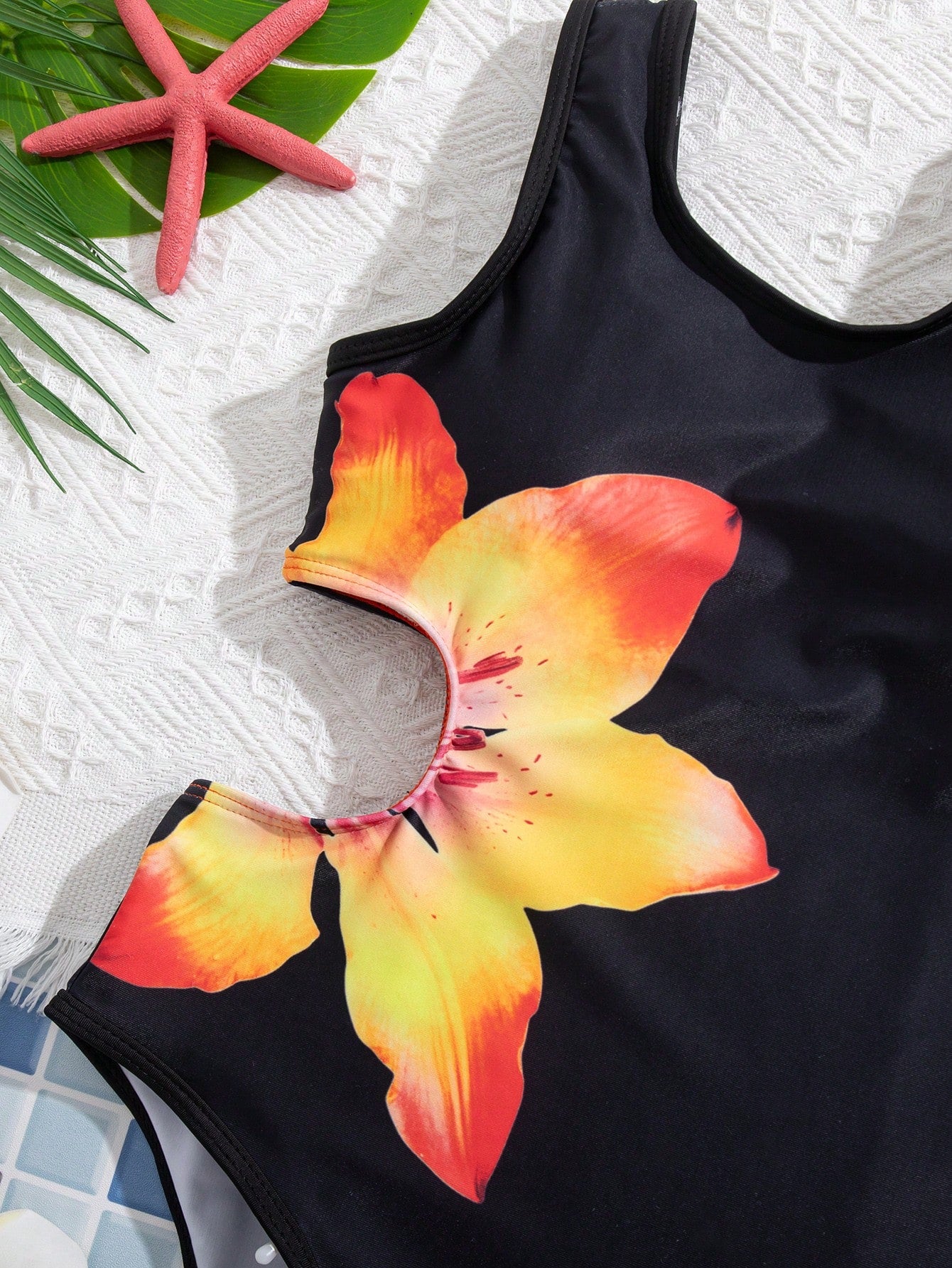 Tween girls' black and white one-piece swimsuit with striped patchwork design, scoop neck, asymmetrical cut-out detail, and fitted vacation swimwear style.