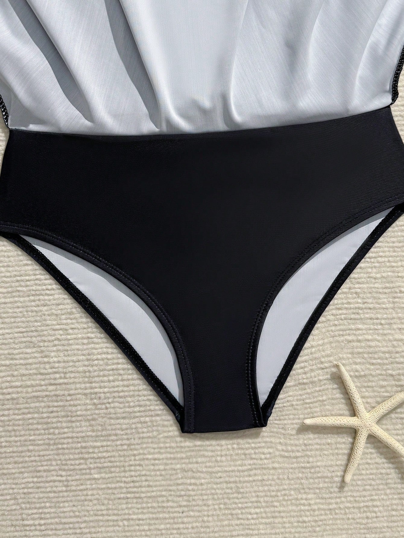 Tween girls one-piece swimsuit in black floral pattern with long sleeves, high neck, front zipper, and a skirt-style bottom.