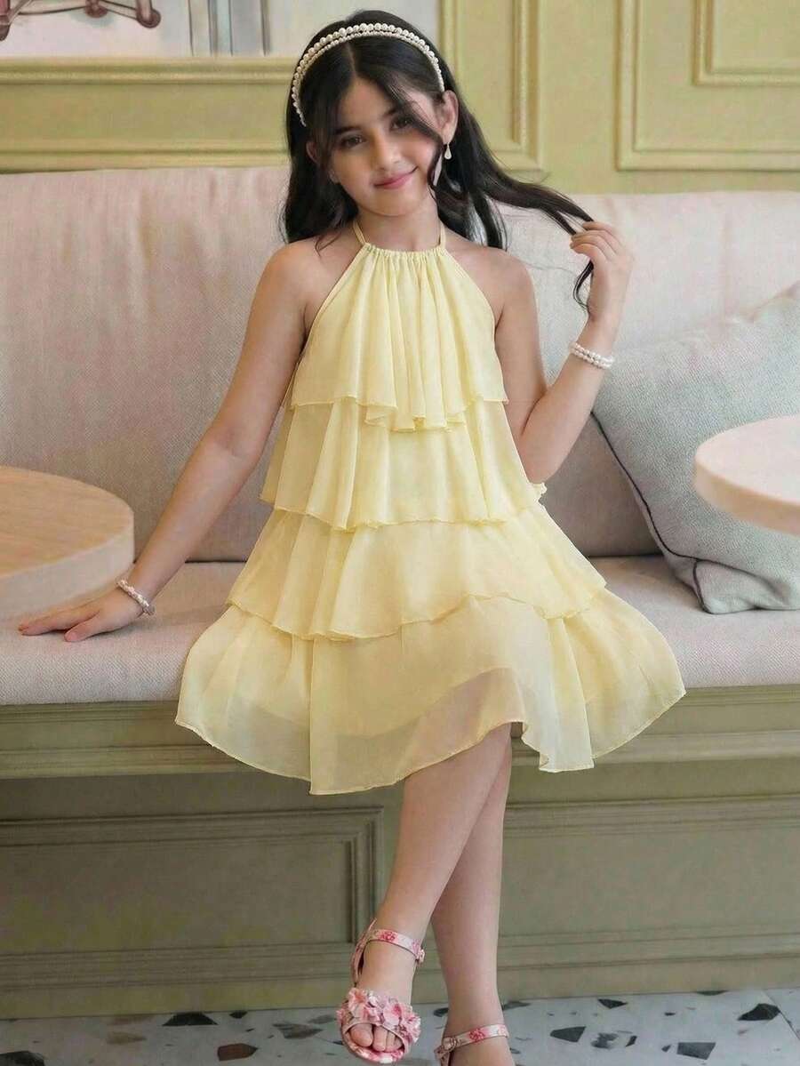 Apricot all-over floral print midi dress for tween girls featuring a sleeveless V-neckline, high waist, button details, and tiered A-line skirt.