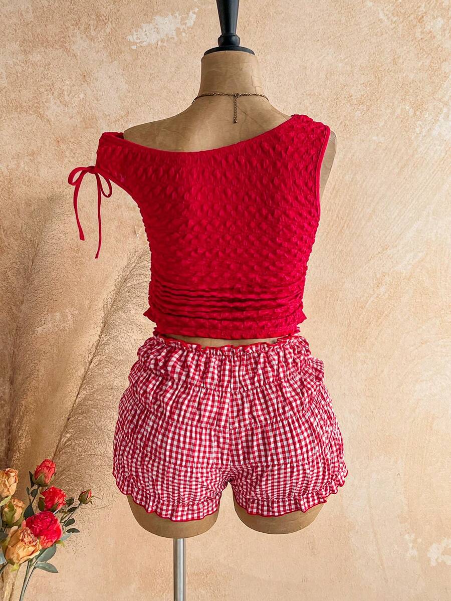 Tween girl wearing a casual 2-piece set featuring a black rib-knit scoop neck tank top and leopard print paperbag waist shorts with a matching belt.