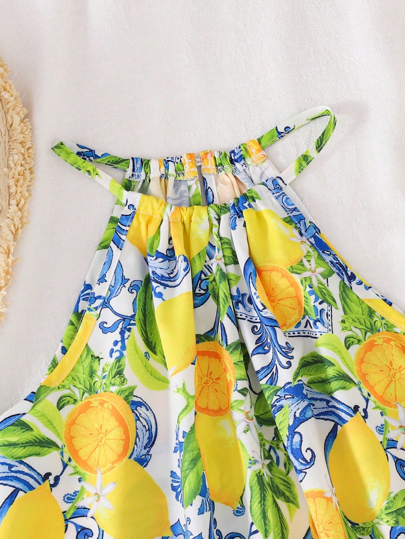 Tween girls floral print dress with halter neckline, sleeveless cold shoulder design, A-line shape, and vacation style.