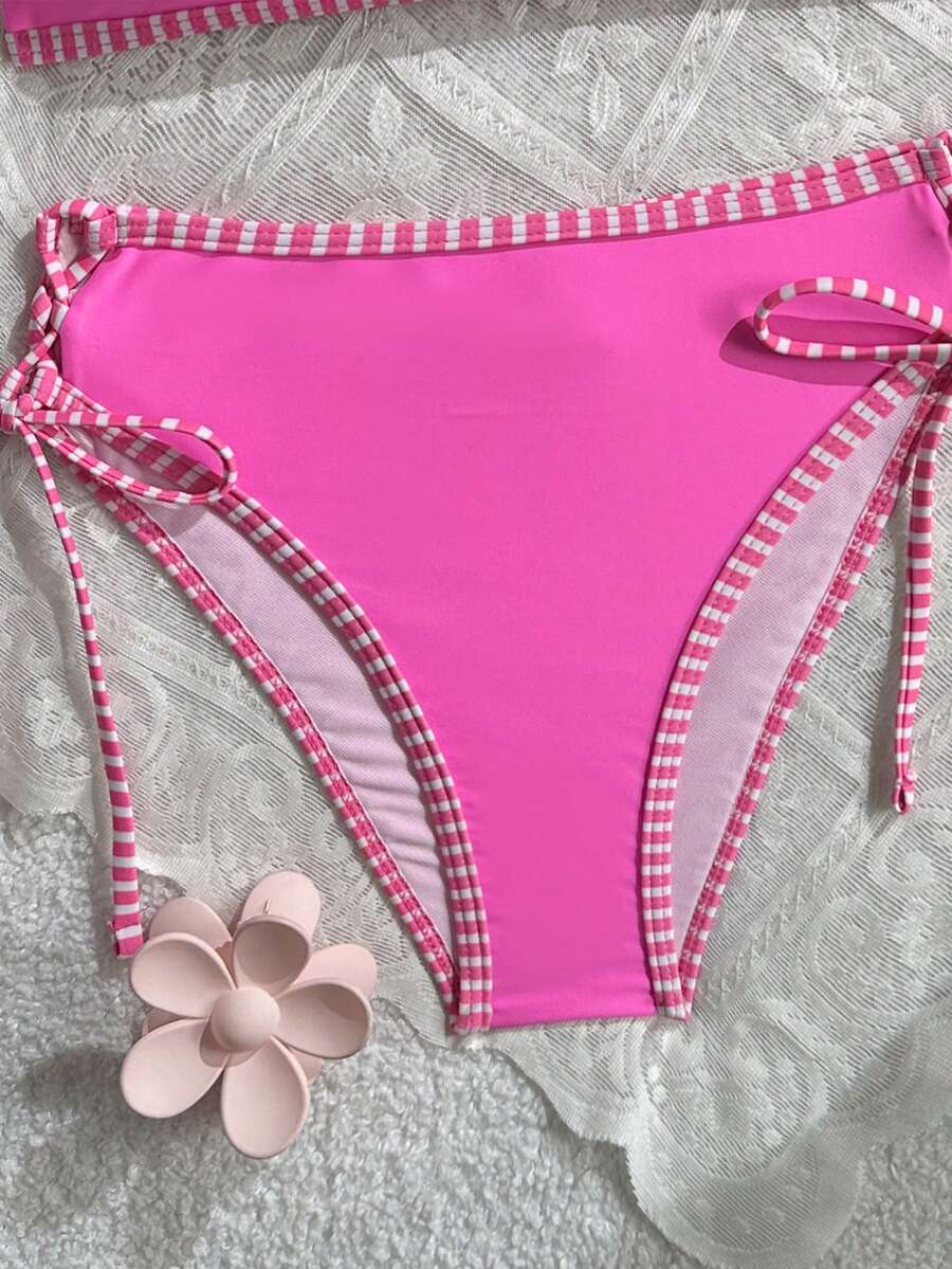 Women's hot pink split bikini set featuring a high waist tie-side bottom and a wireless bandeau top with criss cross details.
