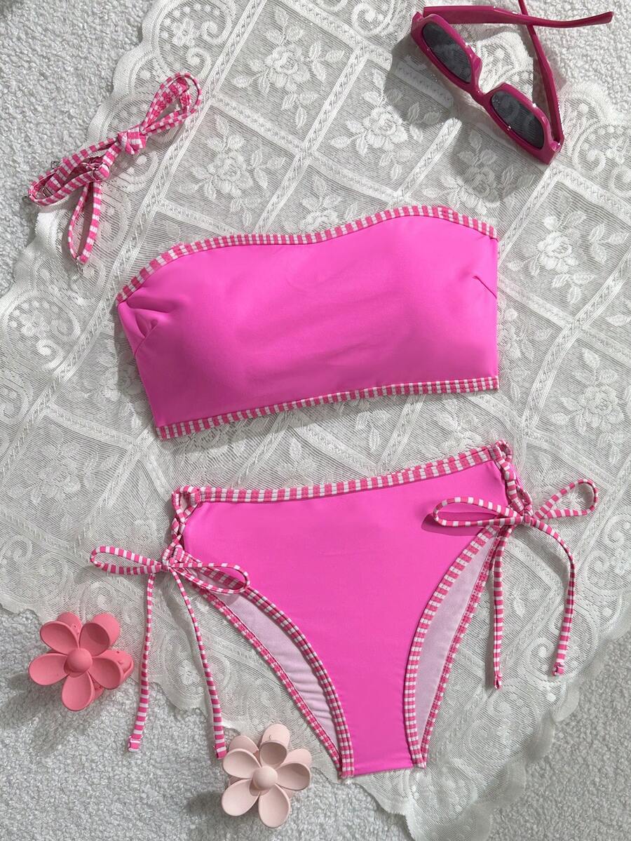 Women's hot pink split bikini set featuring a high waist tie-side bottom and a wireless bandeau top with criss cross details.