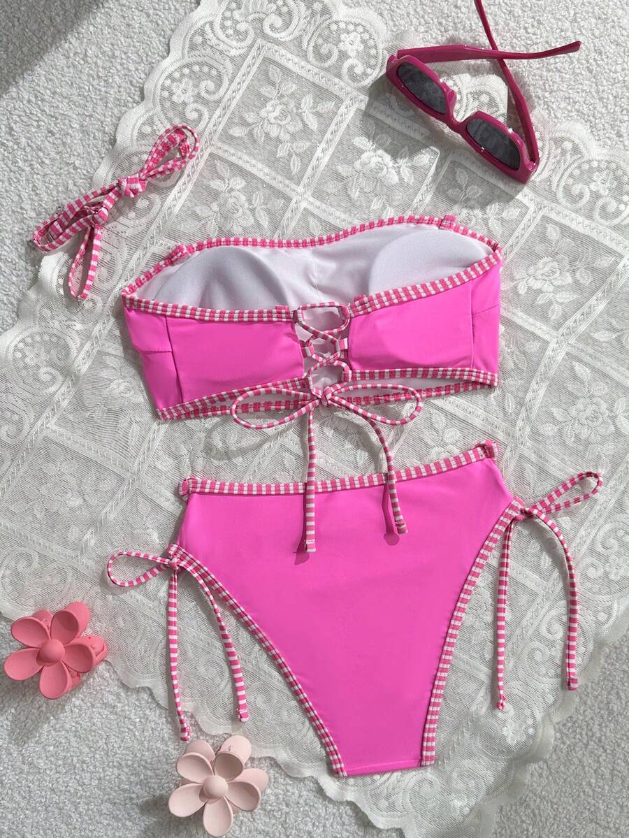 Women's hot pink split bikini set featuring a high waist tie-side bottom and a wireless bandeau top with criss cross details.