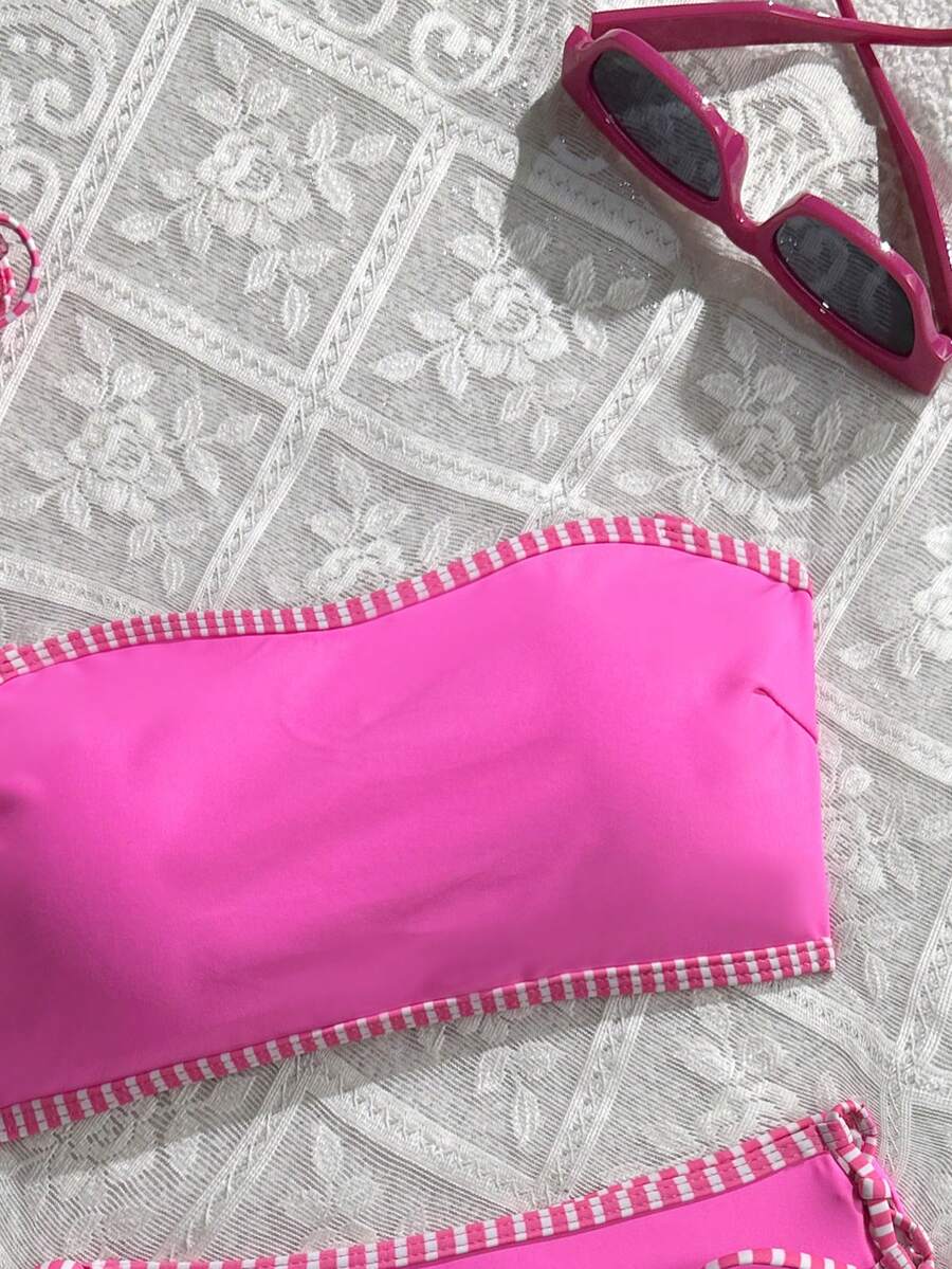 Women's hot pink split bikini set featuring a high waist tie-side bottom and a wireless bandeau top with criss cross details.