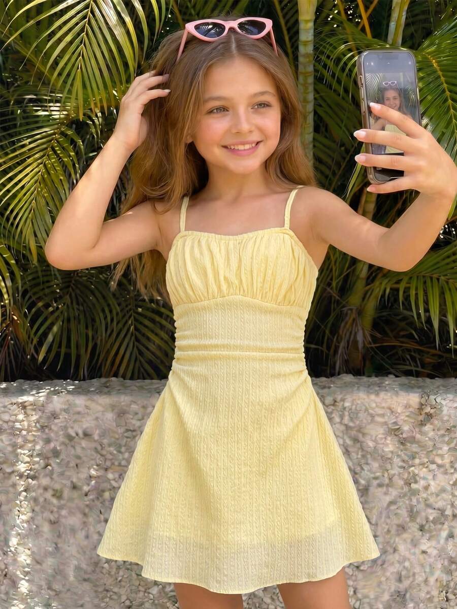 Tween girls blue sleeveless cami dress with spaghetti straps, ruched bust, short slim fit, and vacation-ready style