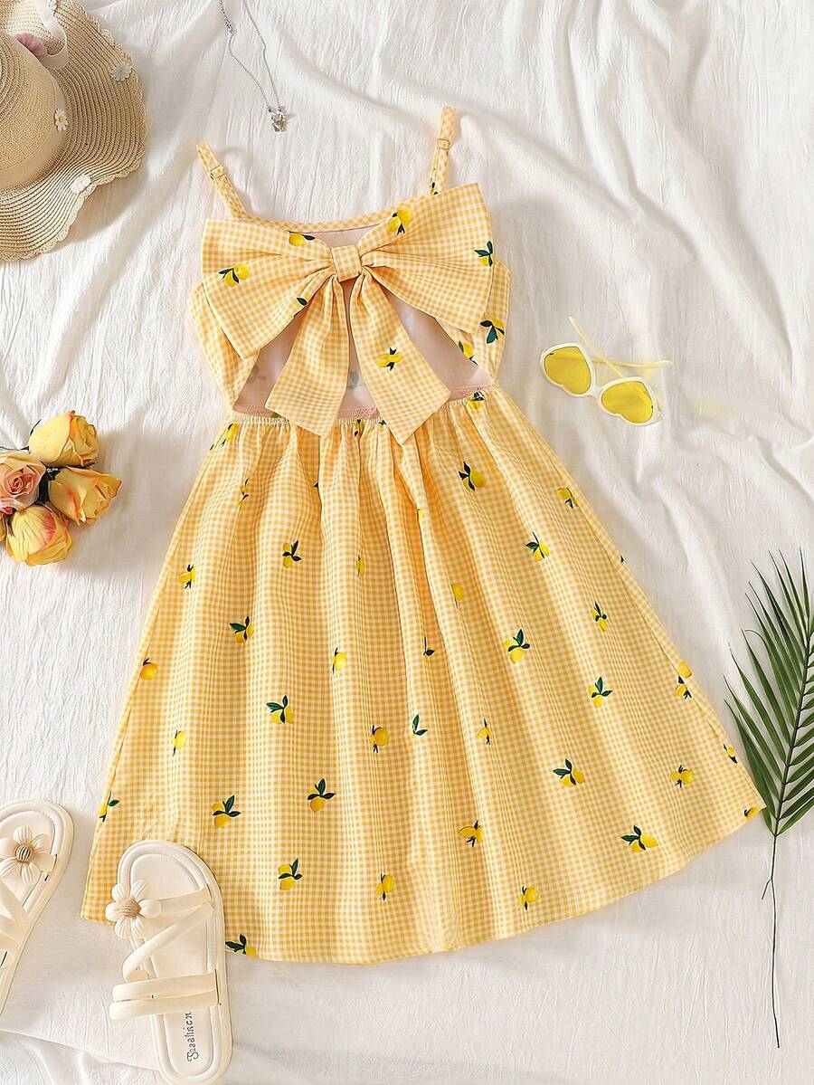Tween girl wearing an apricot floral print sleeveless mini cami dress featuring spaghetti straps, a shirred high waist, flounce hem, and a bow back detail.