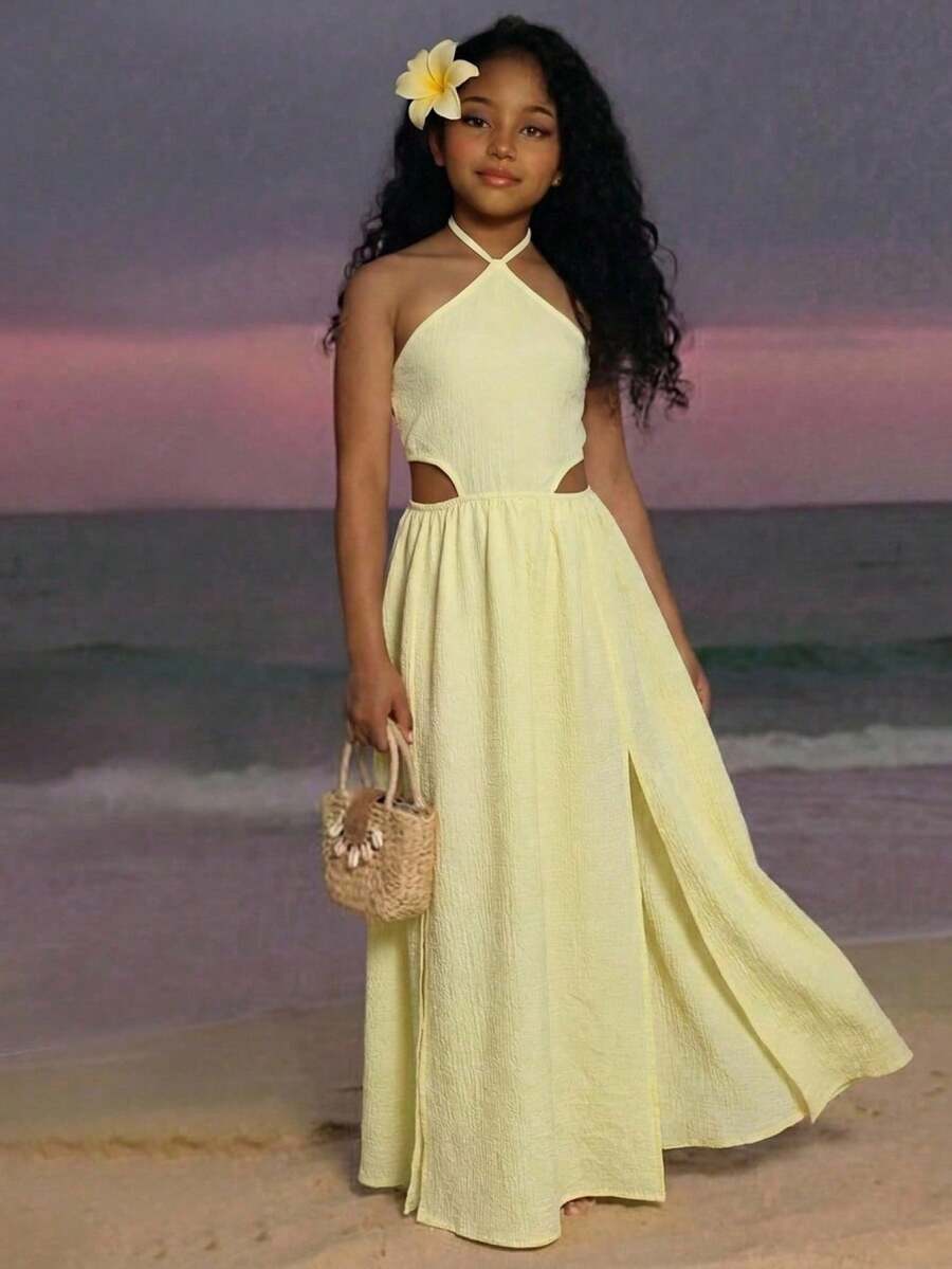 Tween girl yellow long halter dress with cutout waist, split detail, shirred textured fabric, sleeveless design, high waist, and flared hem for beach vacation wear.