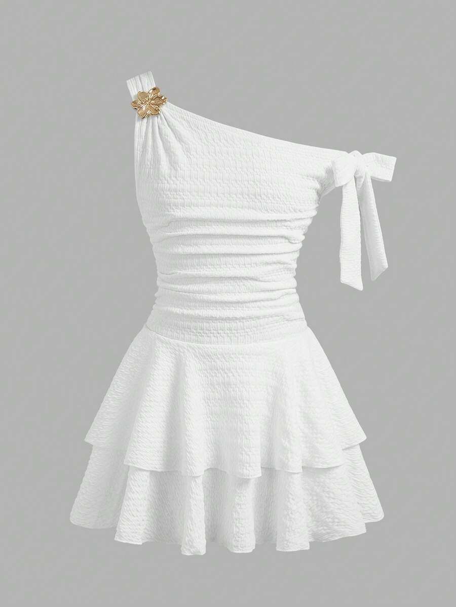 Tween girl wearing an apricot asymmetrical tiered sleeveless party dress with an A-line silhouette.