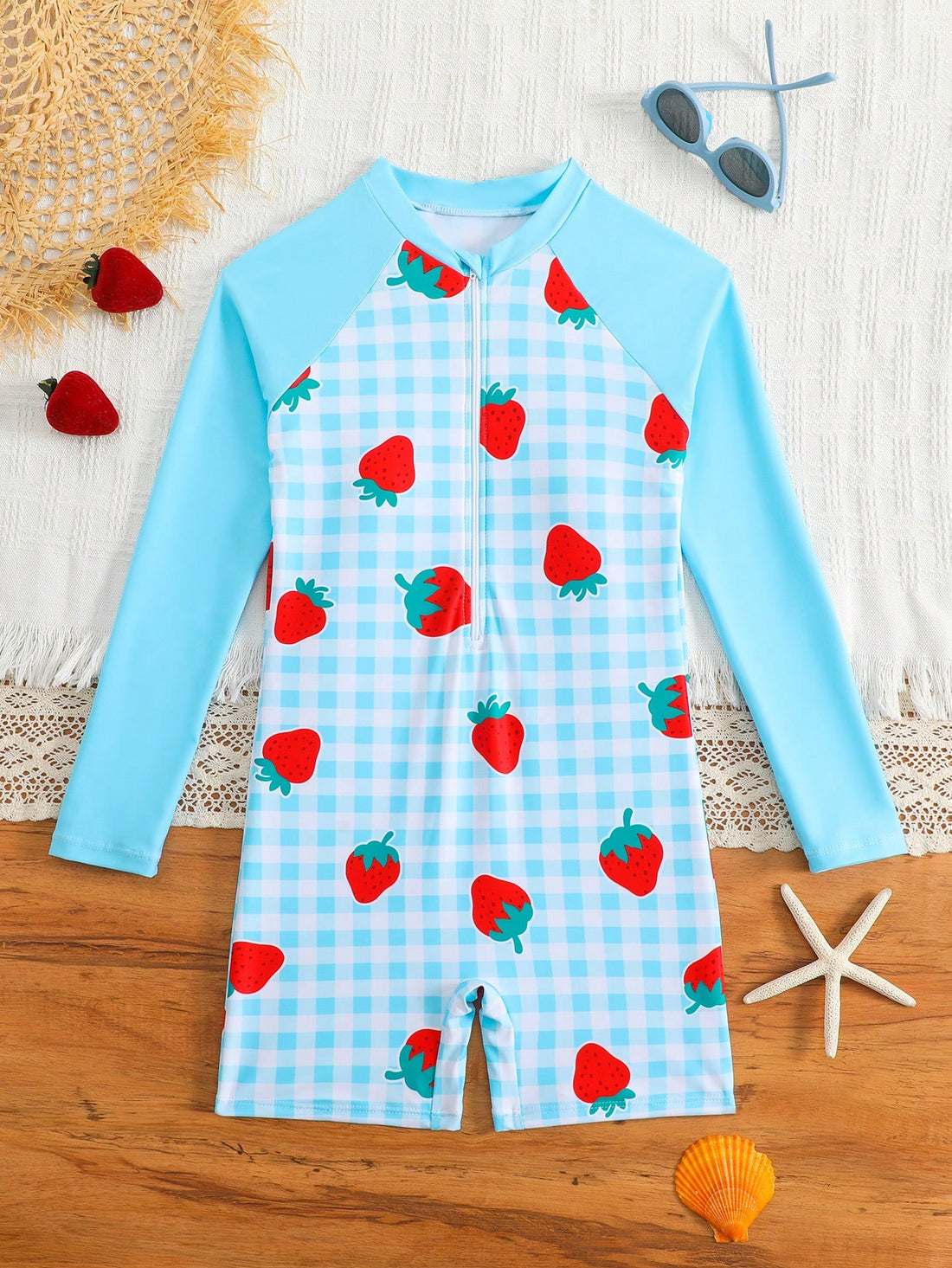 Tween girls one-piece swimsuit featuring a high neck, long sleeves, and shorts bottom, with a back zipper and strawberry plaid digital print on stretch knit fabric. Designed for swimming, vacation, and summer wear.