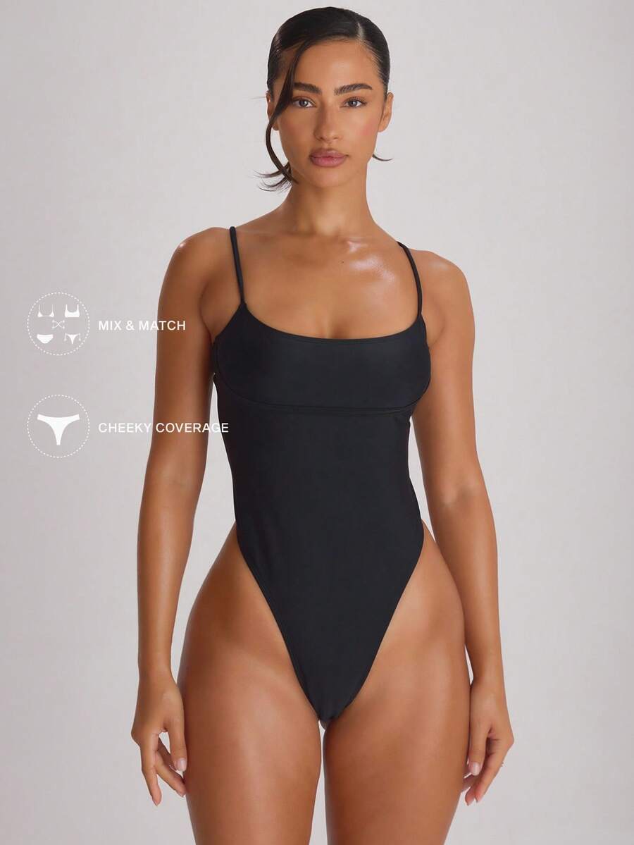 Women's high-leg strappy one-piece swimsuit featuring a plain design, crisscross backless style with buckle detail, spaghetti straps, and removable padding.