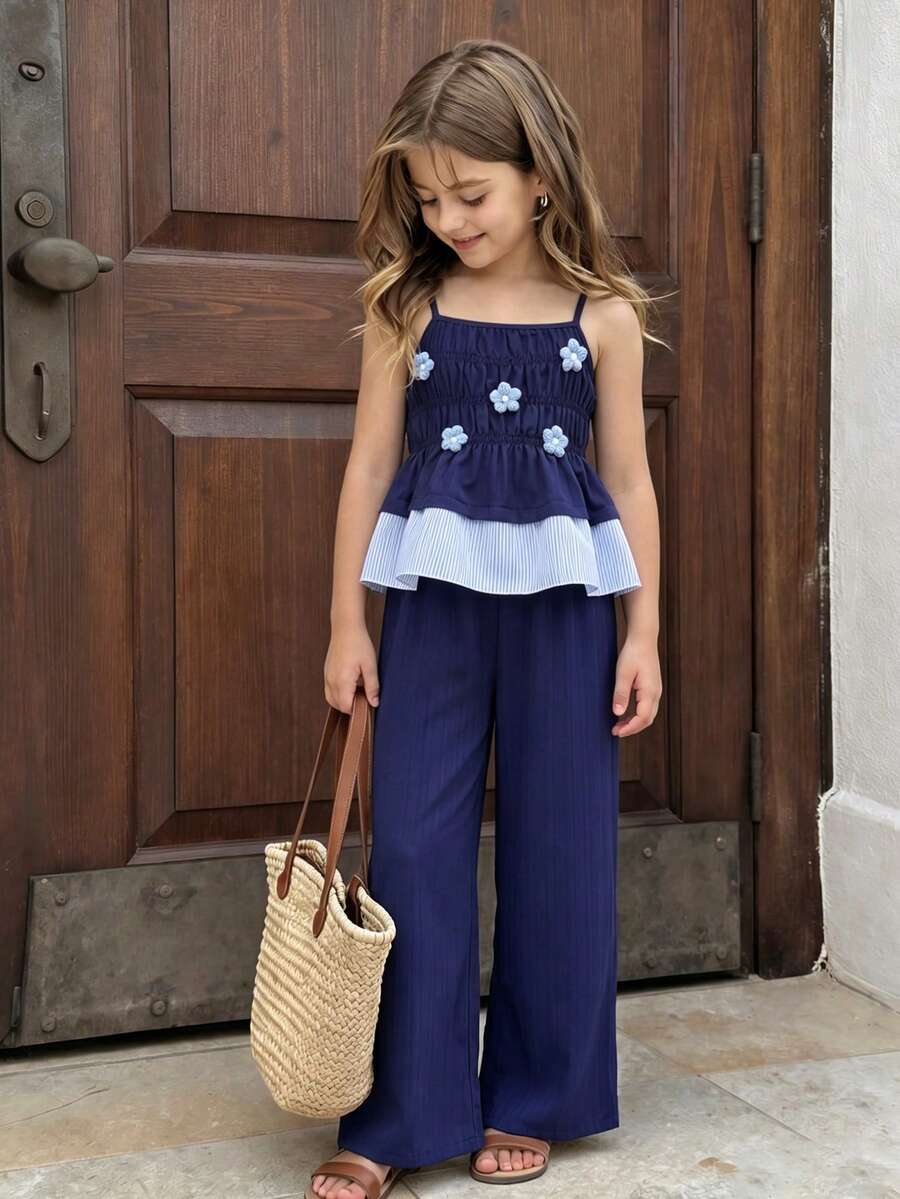 Girls 2-piece summer outfit set featuring a blue bow print camisole top with spaghetti straps and matching high-waisted straight leg pants.