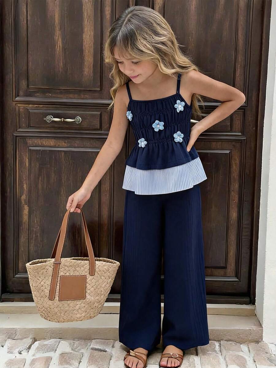 Girls 2-piece summer outfit set featuring a blue bow print camisole top with spaghetti straps and matching high-waisted straight leg pants.