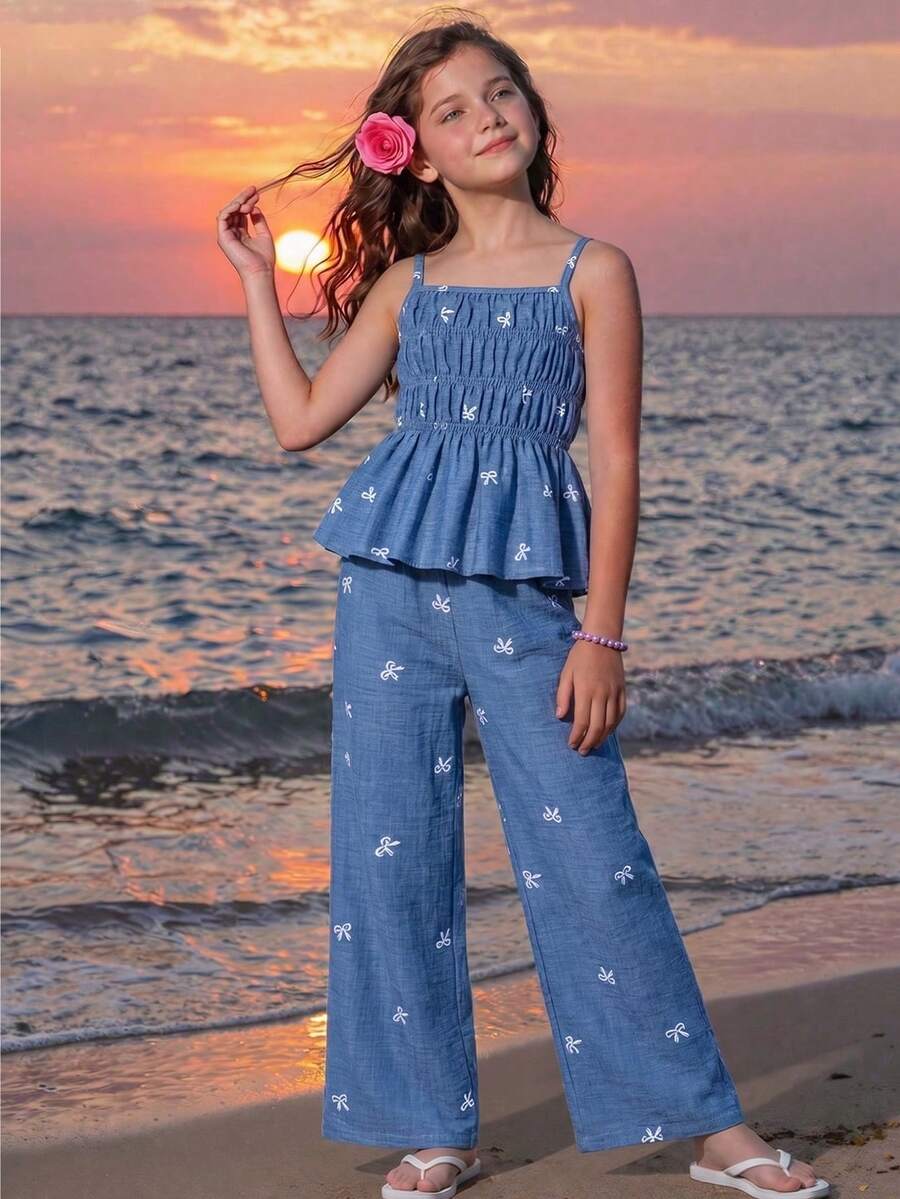 Girls 2-piece summer outfit set featuring a blue bow print camisole top with spaghetti straps and matching high-waisted straight leg pants.