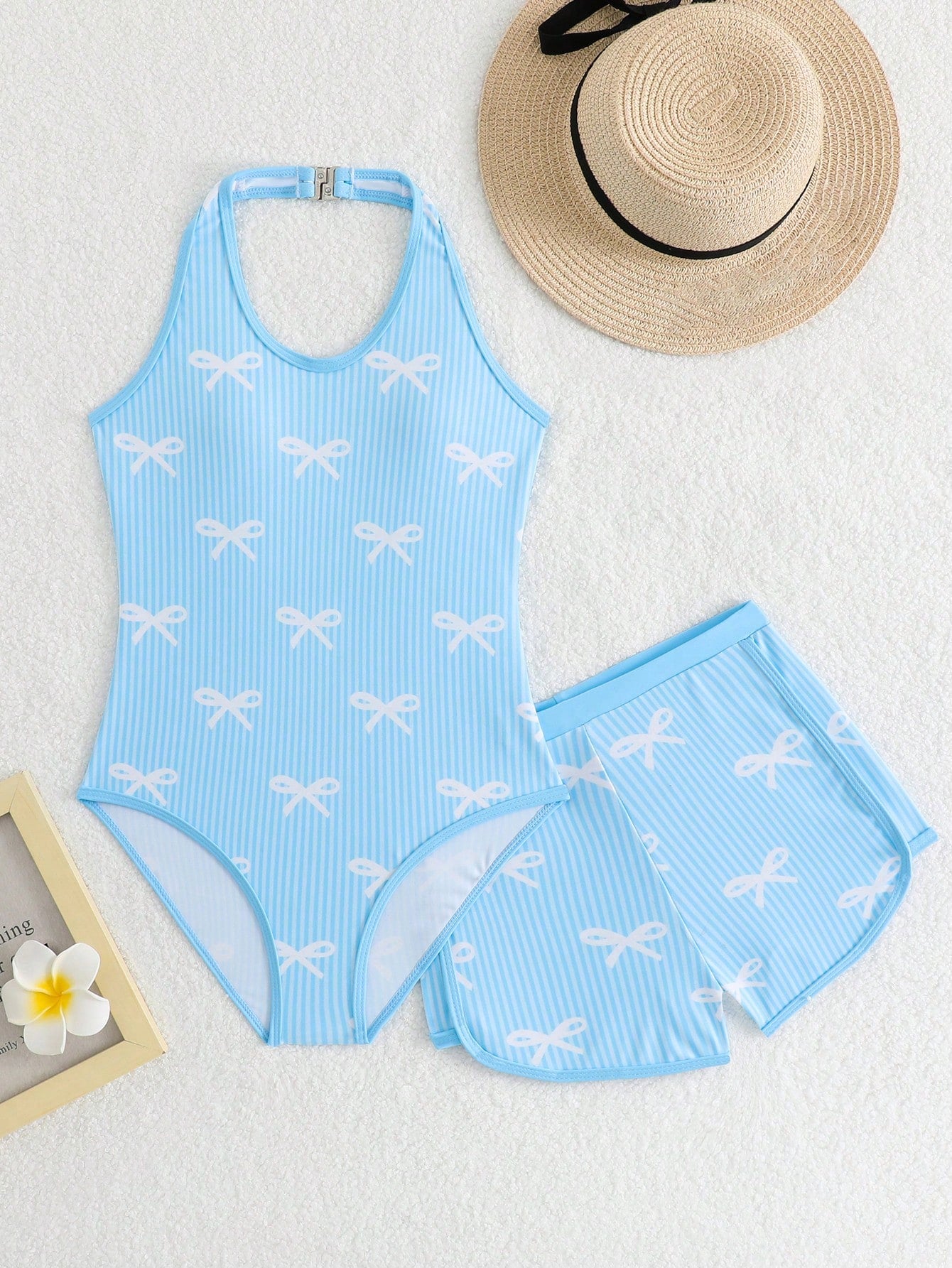 Girls 2-piece swimwear set featuring a butterfly print halter swimsuit top with contrast piping and separate mid-waist shorts; sleeveless, high-stretch, wireless design for beach and vacation wear.