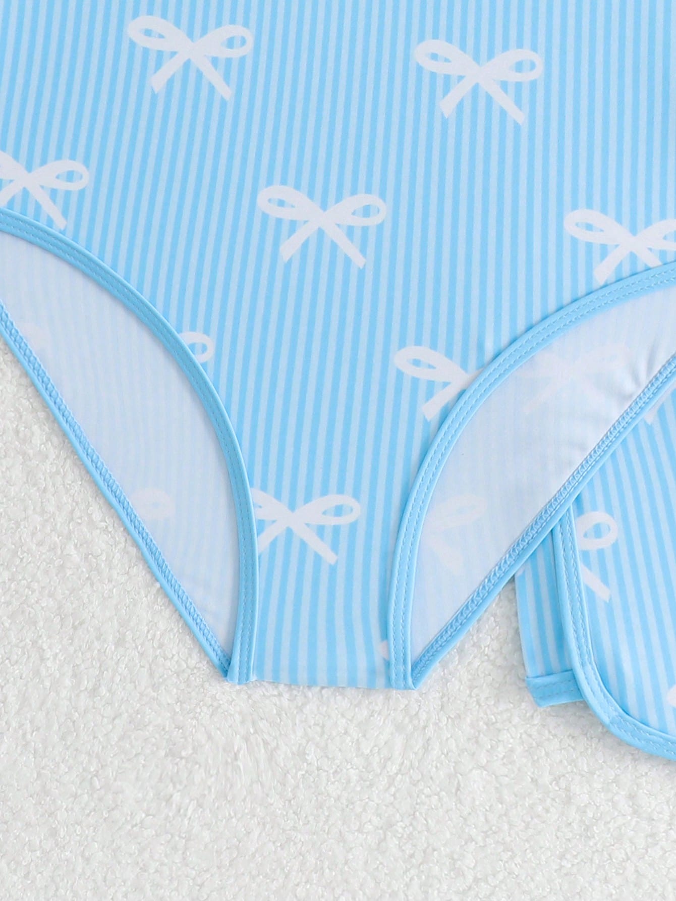 Girls 2-piece swimwear set featuring a butterfly print halter swimsuit top with contrast piping and separate mid-waist shorts; sleeveless, high-stretch, wireless design for beach and vacation wear.