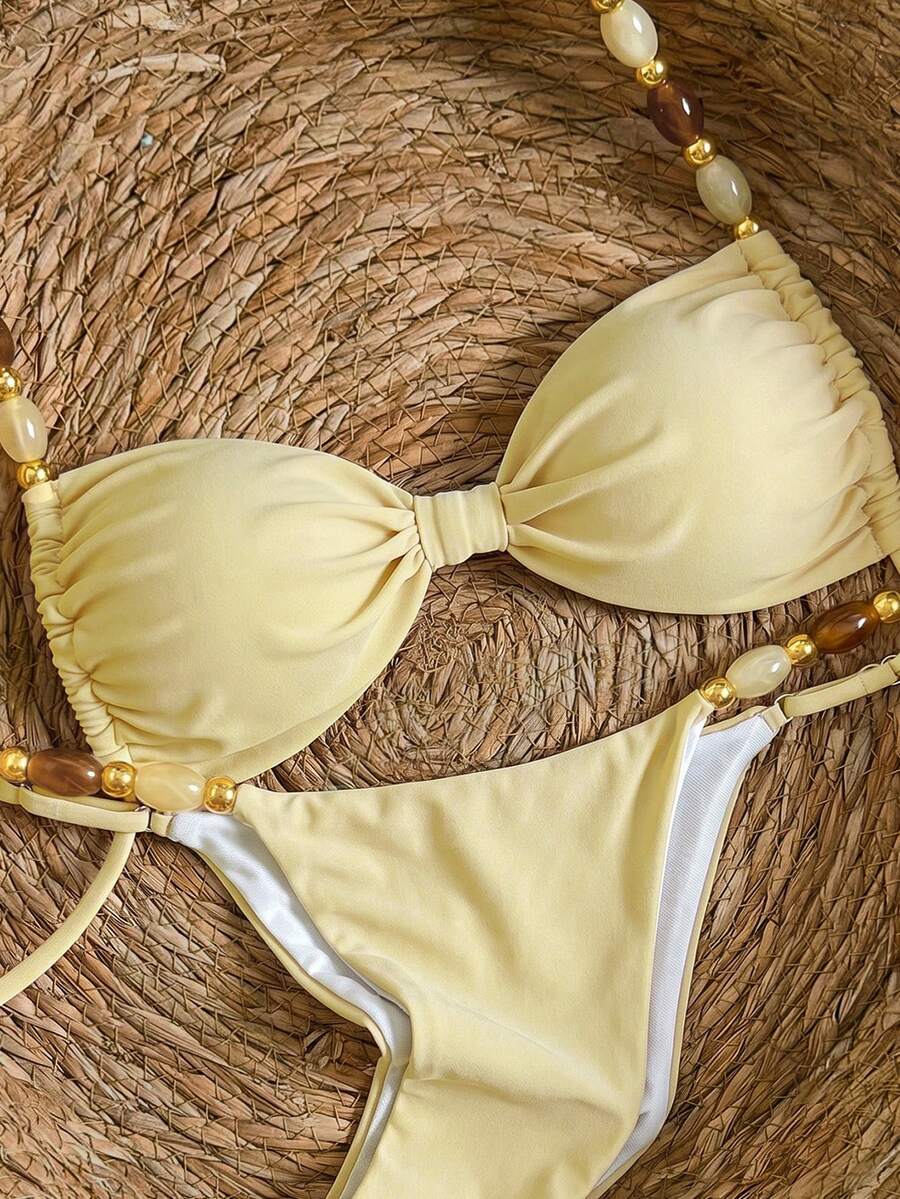 Women's green halter neck bikini set featuring color-block beaded shoulder straps, back tie detail, and high cut bottoms.