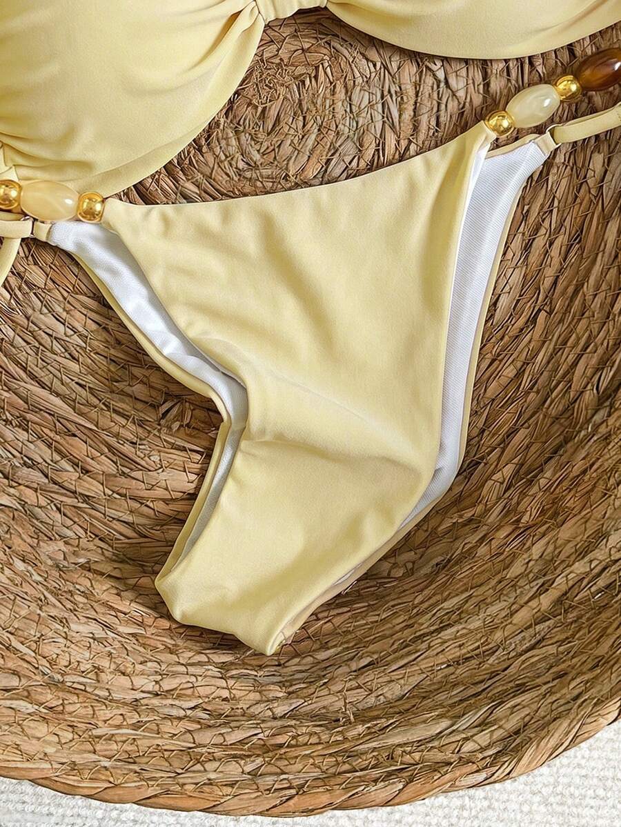 Women's green halter neck bikini set featuring color-block beaded shoulder straps, back tie detail, and high cut bottoms.